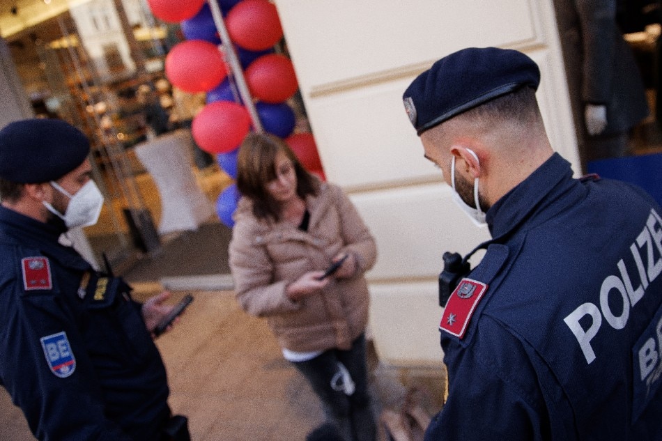 Police officers check the vaccination status of shoppers at the entrance of a store after the Austrian government imposed a lockdown on roughly 2 million people who are not fully vaccinated against the COVID-19 in Vienna, November 16, 2021. Lisi Niesner, Reuters