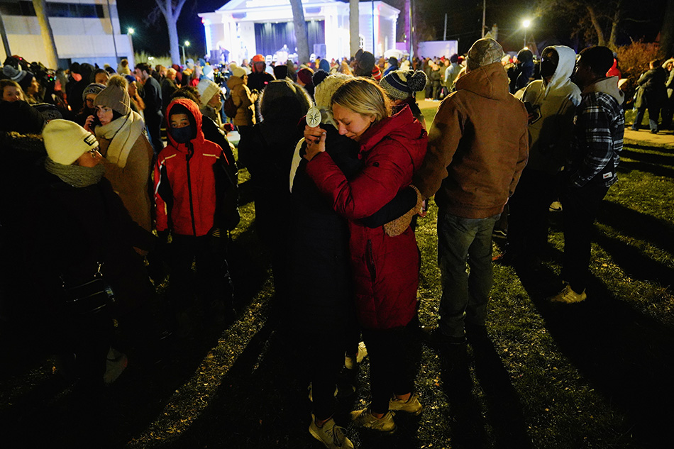 Maddi Maederer, 18, hugs another community member during a candle light vigil in Cutler Park after a car plowed through a holiday parade in Waukesha, Wisconsin, US, Nov. 22, 2021. Cheney Orr, Reuters