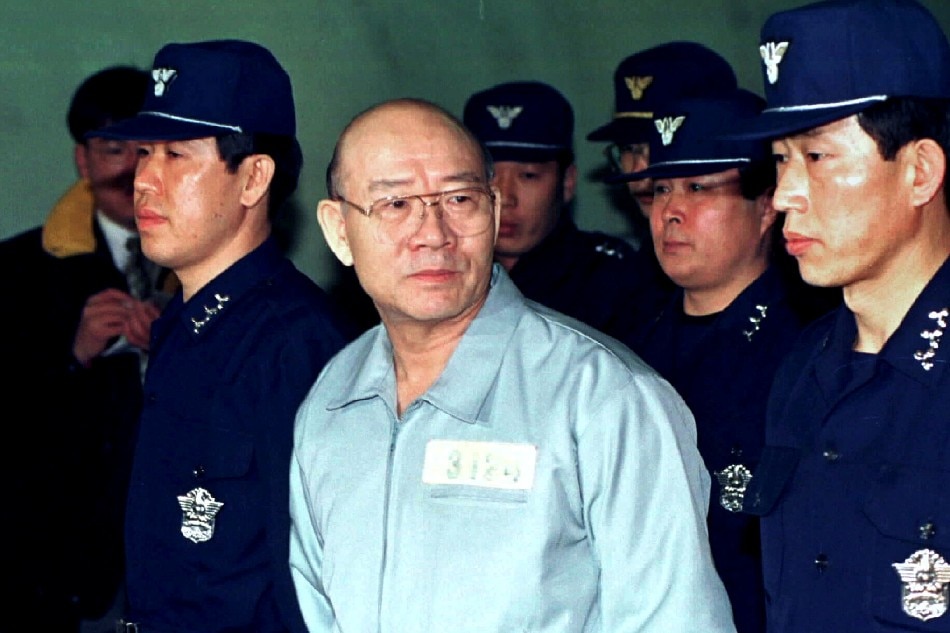 Former South Korean president Chun Doo-hwan, wearing a prison uniform, is escorted by police into the Seoul District Criminal Court where he is on trial facing corruption charges in this file photo taken in 1996. Reuters/File