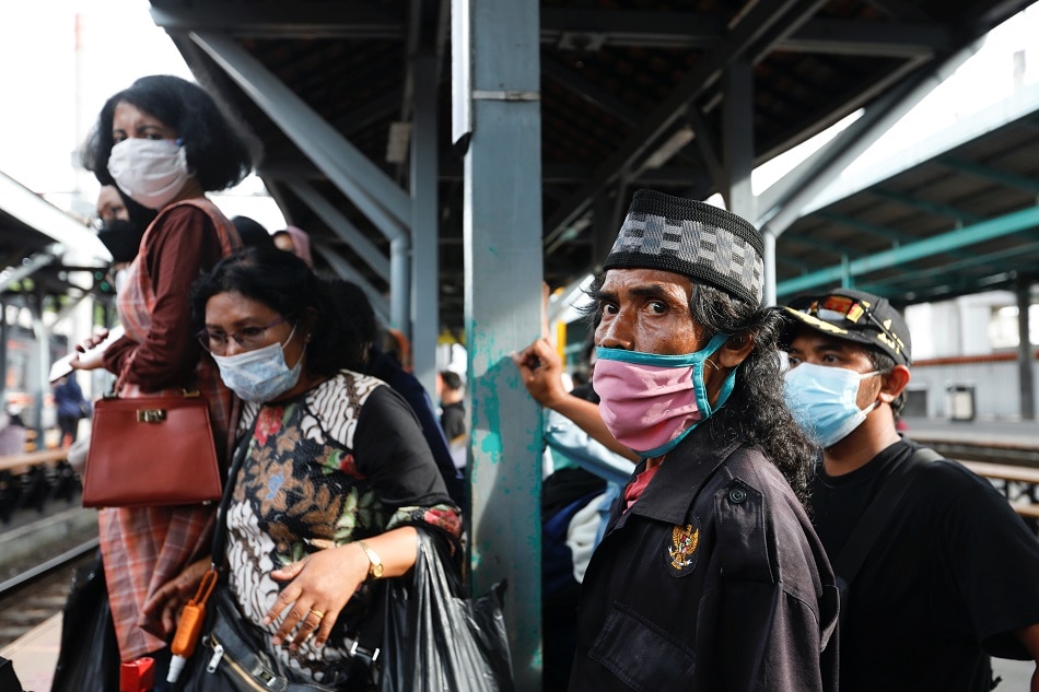 People wearing protective face masks stand as they wait for a train during rush hour at a train station in Jakarta, Indonesia, November 22, 2021. REUTERS/Ajeng Dinar Ulfiana