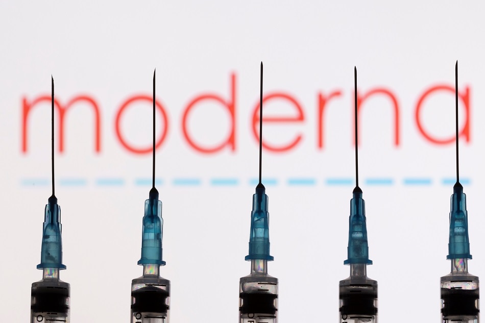 Syringes with needles are seen in front of a displayed Moderna logo in this illustration taken, November 27, 2021. Dado Ruvic, Reuters/Illustration/file