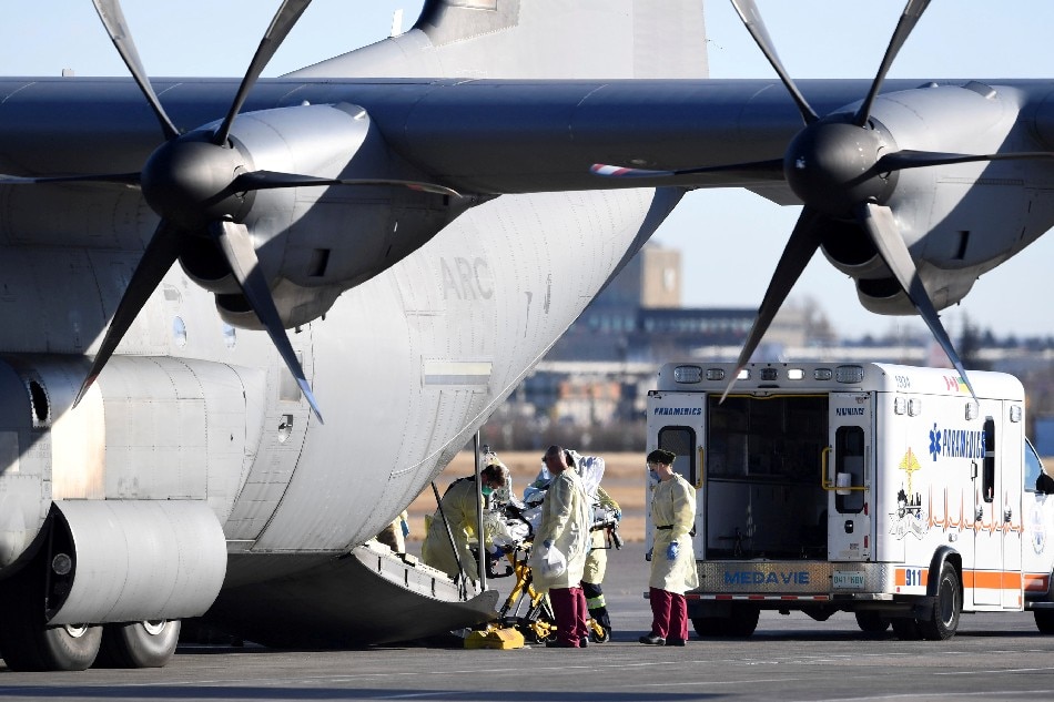 Medical personnel load a patient onto a Royal Canadian Air Force CC-130J Hercules transport aircraft, after the province of Saskatchewan said it would be sending COVID patients from overloaded ICU wards to Ontario hospitals, in Saskatoon, Saskatchewan, Canada October 28, 2021. Liam Richards, Reuters File Photo