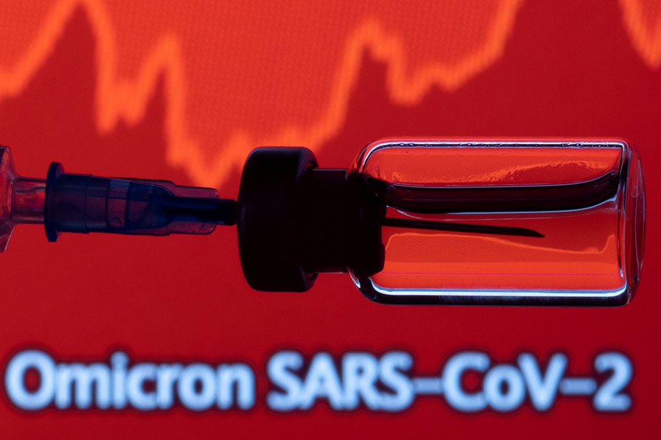 A vial and a syringe are seen in front of a displayed stock graph and words Omicron SARS-CoV-2 in this illustration taken, November 27, 2021. Dado Ruvic, Reuters illustration/file