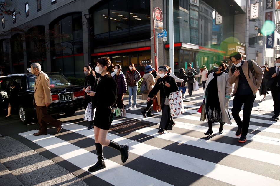 People cross the street in the Ginza shopping area, on the first day of Japan's closed borders to prevent the spread of the Omicron variant of coronavirus, in Tokyo, Japan November 30, 2021. REUTERS/Androniki Christodoulou