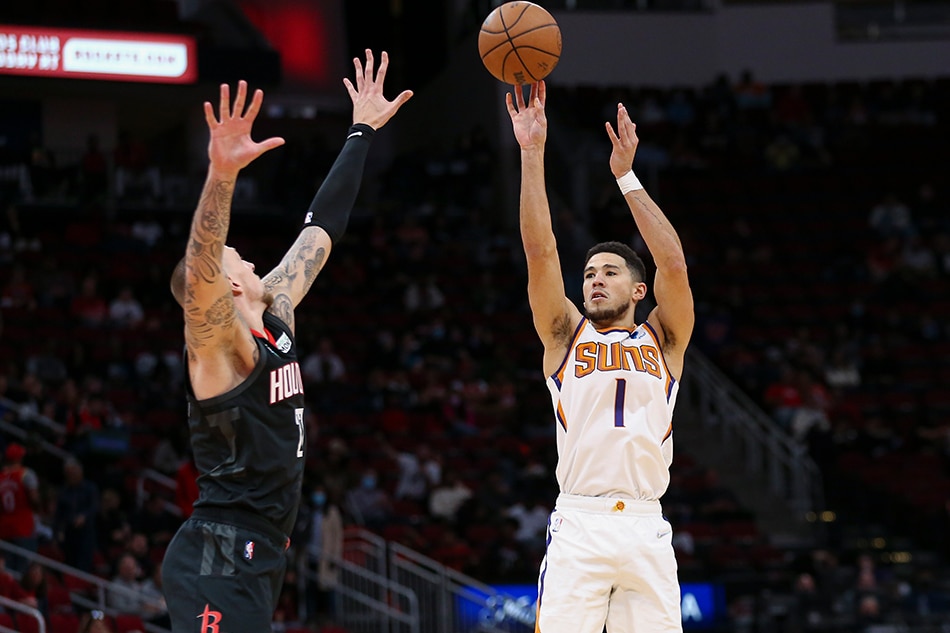 Phoenix Suns guard Devin Booker (1) shoots the ball as Houston Rockets center Daniel Theis (27) defends during the first quarter at Toyota Center. Troy Taormina, USA TODAY Sports/Reuters