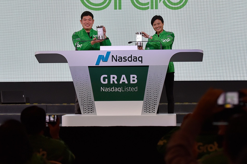 Grab's CEO Anthony Tan and co-founder Tan Hooi Ling pose for photos with the Nasdaq Crystal they received at the Grab Bell Ringing Ceremony, at a hotel in Singapore, December 2, 2021. Caroline Chia, Reuters
