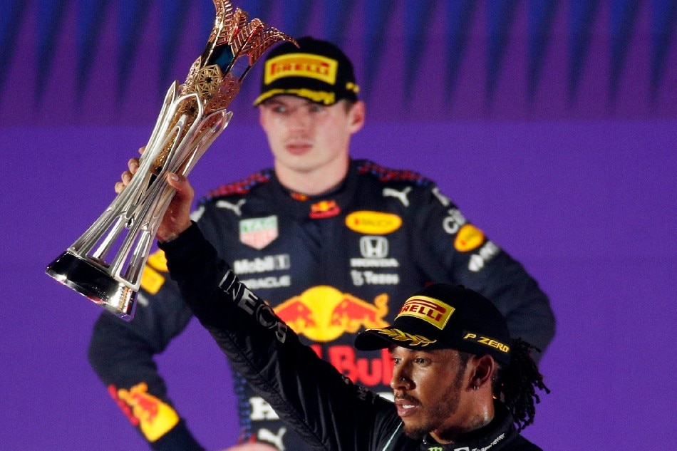 Mercedes' Lewis Hamilton celebrates with the trophy on the podium after winning the race as second placed Red Bull's Max Verstappen looks on. Hamad I Mohammed, Reuters
