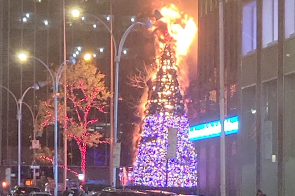 Christmas tree burns outside Fox News building in New York City, US, Dec. 8, 2021 in this still image obtained from a social media video. Twitter @RajeloNess/via Reuters