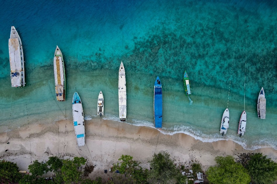 This aerial picture taken on November 22, 2021 shows boats anchored along an empty beach on Gili Trawangan resort island. The coronavirus pandemic has shuttered almost all the resorts and restaurants across Indonesia's Gili Islands, famed for their turquoise waters, sandy beaches, and diverse marine life. Bay Ismoyo, Agence France-Presse 