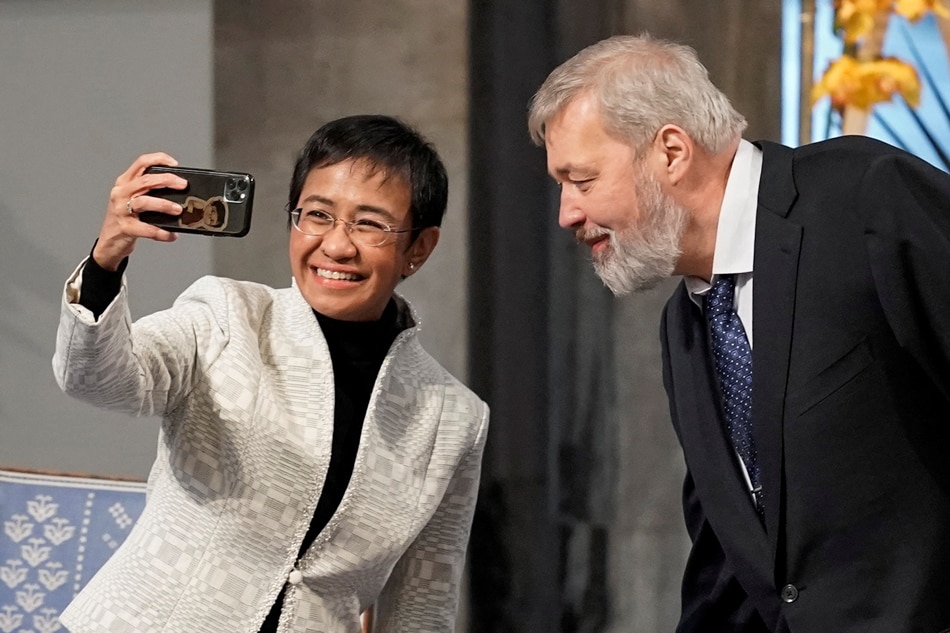  Veteran Journalists Maria Ressa and Dmitry Muratov take a selfie at the 2021 Nobel Peace Prize award ceremony. December 10, 2021. Heiko Junge/NTB/via Reuters