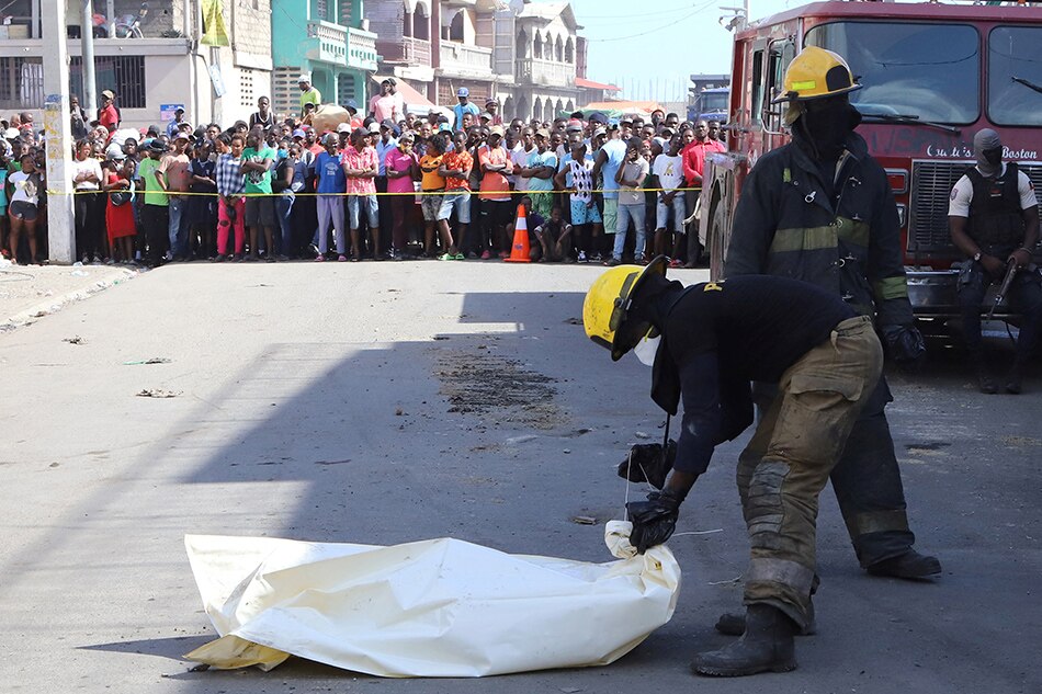 A crowd gathers as emergency workers secure human remains found after a fuel truck exploded killing dozens of people amid reports that nearby residents had attempted to take fuel from the vehicle before it exploded, in Cap Haitien, Haiti, Dec. 15, 2021. Ralph Tedy Erol, Reuters