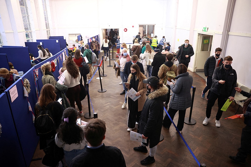 People queue at a coronavirus disease vaccination center in London, December 15, 2021. Hannah McKay, Reuters