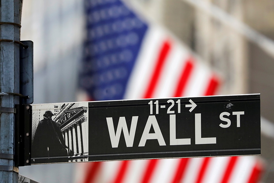 A street sign for Wall Street is seen outside the New York Stock Exchange (NYSE) in New York City, New York, U.S., July 19, 2021. REUTERS/Andrew Kelly/File Photo/File Photo