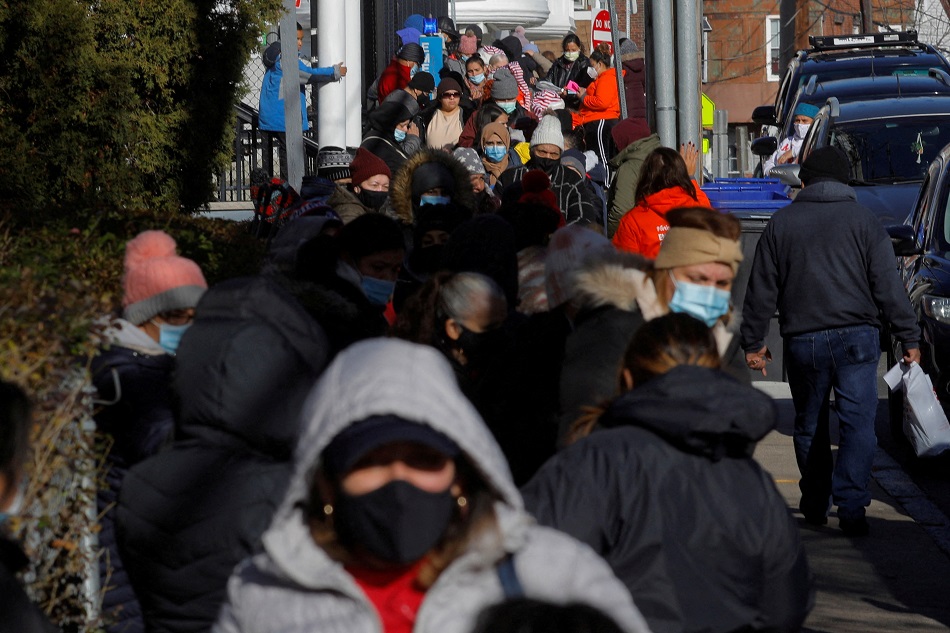 Residents wait in a line extending around the block for the Christmas holiday food pantry, which includes free groceries, toys and home test kits for COVID-19, at La Colaborativa, a non-profit social service organization, in Chelsea, Mass., December 21, 2021. Brian Snyder, Reuters
