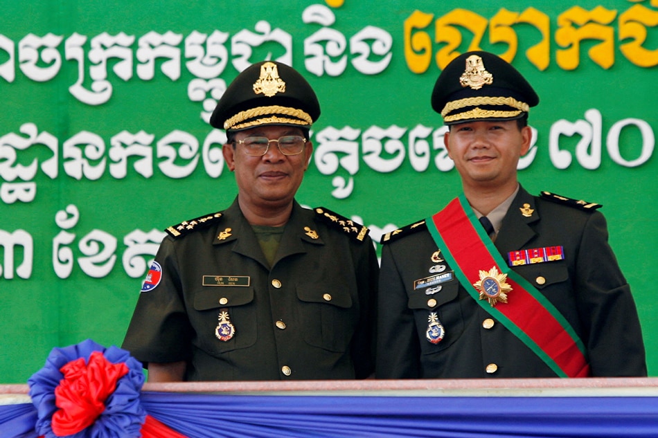 Cambodia's Prime Minister Hun Sen (L) poses with his son Hun Manet on the outskirts of Phnom Penh October 13, 2009. Chor Sokunthe, Reuters file photo