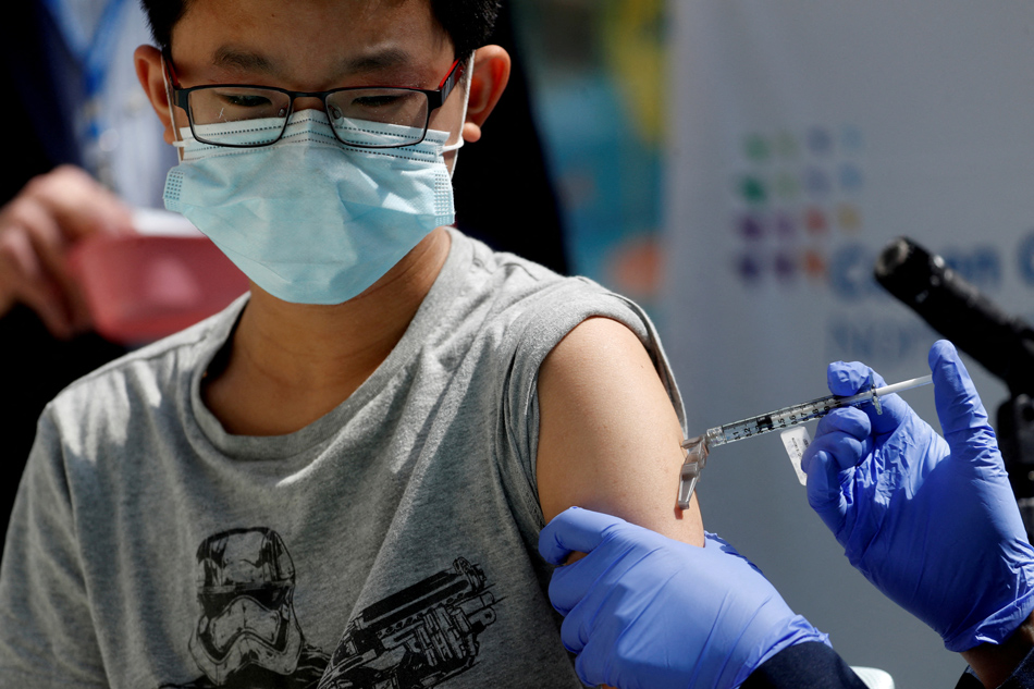 Brendan Lo (13) receives a dose of the Pfizer-BioNTech vaccine for the coronavirus disease (COVID-19) at Northwell Health