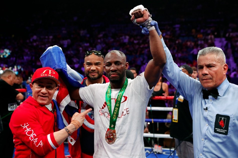 Yordenis Ugas (C) poses with referee Russell Mora and members of his team after defeating Omar Figueroa Jr. during a welterweight bout at MGM Grand Garden Arena on July 20, 2019 in Las Vegas, Nevada. Ugas won the fight by unanimous decision. File photo. Steve Marcus, Getty Images/AFP