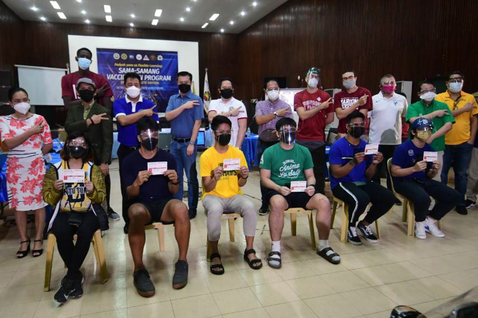 UAAP student-athletes receive their COVID-19 vaccination cards after a vaccination drive on Wednesday. Mark Demayo, ABS-CBN News