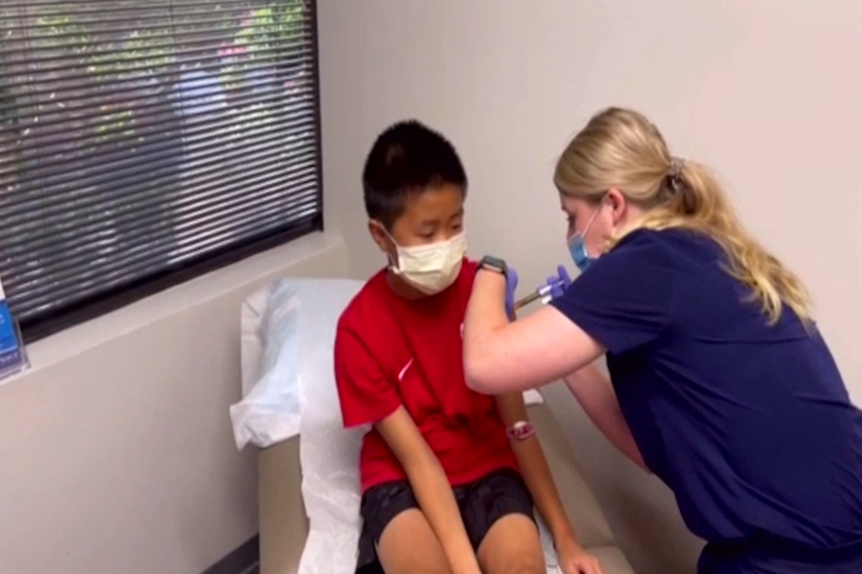 9-year-old Avery Solomon gets his first Moderna vaccine dose.