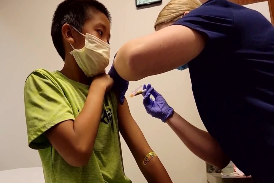 8-year-old Cal Solomon gets his first Moderna vaccine dose.