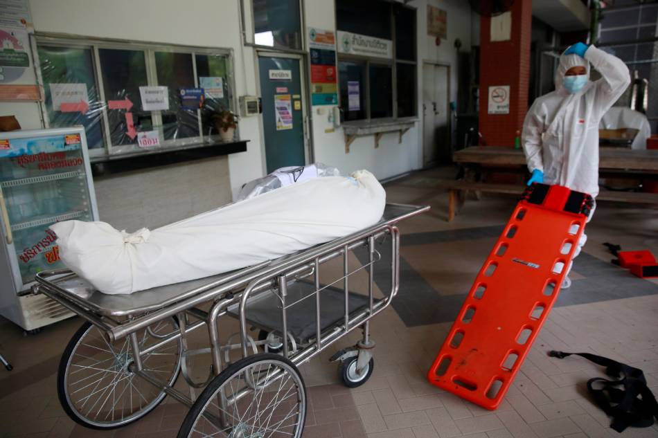Health care workers move a dead body to a container after a hospital morgue overwhelmed by COVID-19 deaths begun to store bodies in refrigerated containers, as the country struggles to deal with its biggest outbreak to date, in Pathum Thani, Thailand July 31, 2021. Soe Zeya Tun, Reuters