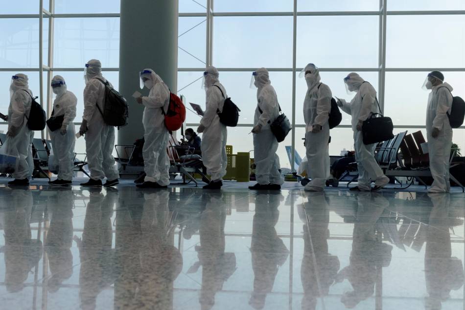 Passengers wearing protective suits (PPE) line up to board their plane for an international flight at Hong Kong airport amid the spread of the coronavirus disease (COVID-19) on July 9, 2021. Thomas Peter, Reuters/File Photo