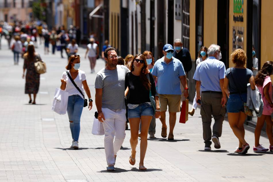 Two tourists walk without face masks in La Laguna on the day the Canary Islands government imposed stricter rules to control a surge in COVID-19 cases, on the island of Tenerife, Spain, July 26, 2021. Borja Suarez, Reuters/File