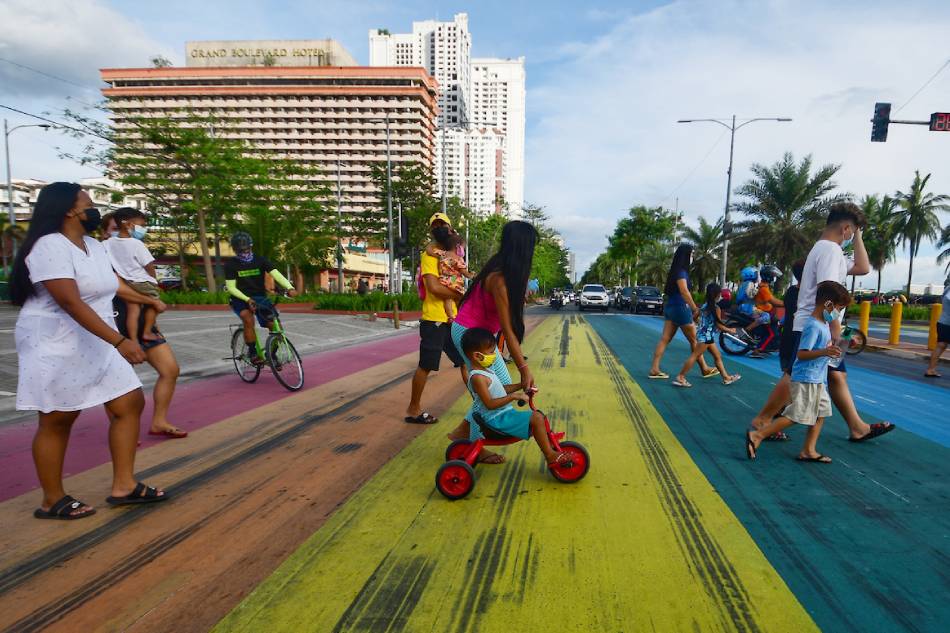 Families stroll along the Manila baywalk on July 11, 2021. The Inter-Agency Task Force on COVID-19 recently allowed children ages five and up to go outdoors, except in facilities such as malls, in areas under GCQ, GCQ with restrictions, and MGCQ. Mark Demayo, ABS-CBN New/File