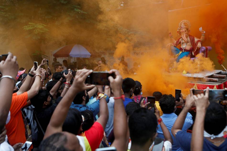 Devotees flock to catch a glimpse of an idol of the Hindu God Ganesh, the deity of prosperity, as it leaves a workshop ahead of the Ganesh Chaturthi festival in Mumbai, India, Sept. 5, 2021. Francis Mascarenhas, Reuters