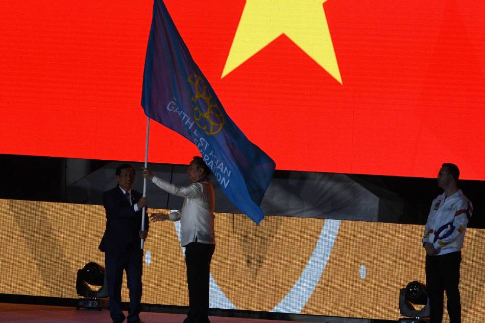 Philippines' Olympic committee chairman Bambol Tolentino (R) hands over the SEA Games flag to a Vietnamese official during the closing ceremony of the SEA Games (Southeast Asian Games) at the athletics stadium in Clark, north of Manila on December 11, 2019. Ted Aljibe, AFP