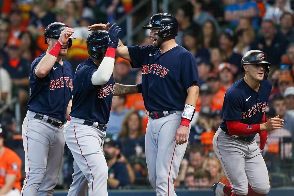 Boston Red Sox third baseman Rafael Devers (11) is congratulated by catcher Kevin Plawecki (25) after hitting a grand slam against the Houston Astros during the second inning in game two of the 2021 ALCS at Minute Maid Park. Thomas Shea, USA TODAY Sports/Reuters.