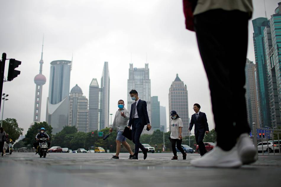 People walk along at financial district of Lujiazui in Shanghai, China October 15, 2021. Aly Song, Reuters