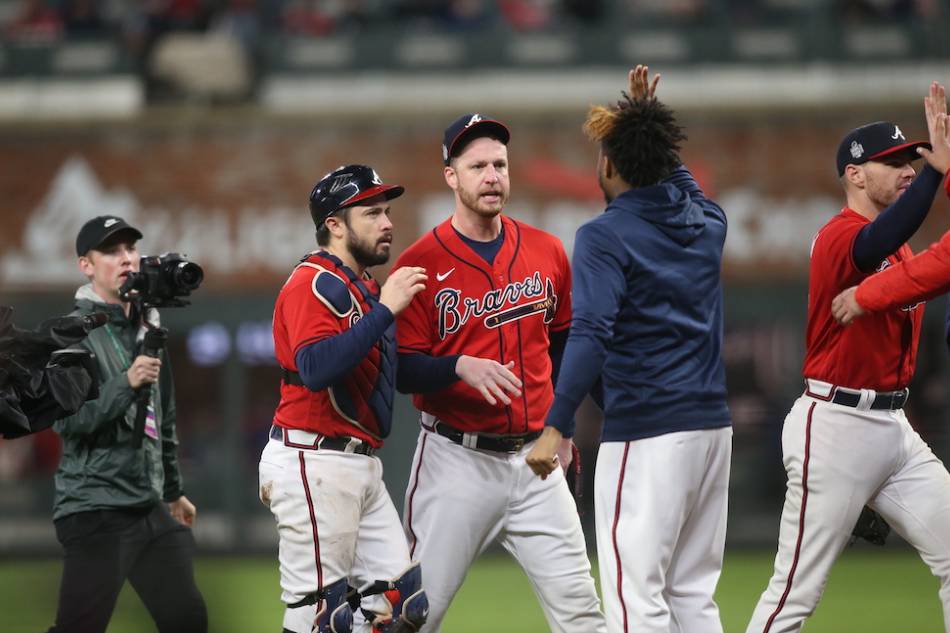 Atlanta Braves catcher Travis d'Arnaud (left) and relief pitcher Will Smith (51) celebrate with injured Brave Ronald Acuna Jr after defeating the Houston Astros during Game 3 of the 2021 World Series at Truist Park. Brett Davis, USA TODAY Sports/Reuters