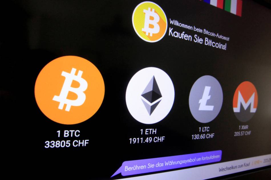The exchange rates and logos of Bitcoin (BTH), Ether (ETH), Litecoin (LTC) and Monero (XMR) are seen on the display of a cryptocurrency ATM of blockchain payment service provider Bity at the House of Satoshi bitcoin and blockchain shop in Zurich, Switzerland, June 25, 2021. Arnd Wiegmann, Reuters, File 
