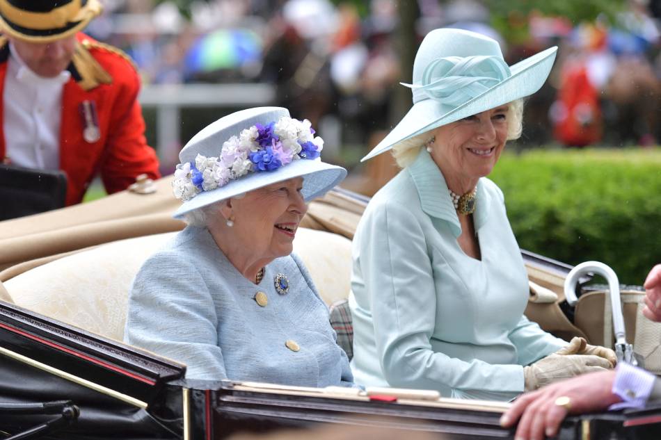 In this file photo taken on June 19, 2019, Britain's Queen Elizabeth II (C) and Britain's Camilla, Duchess of Cornwall (R) arrive by carriage on day two of the Royal Ascot horse racing meet, in Ascot, west of London. A gradual changing of the guard is happening at the head of Britain's royal family, as Queen Elizabeth II steps back from public engagements due to her advanced age and health. Her son and heir Charles, Prince of Wales' wife, Camilla, is increasingly stepping into the fray. Daniel Leal-Olivas / AFP