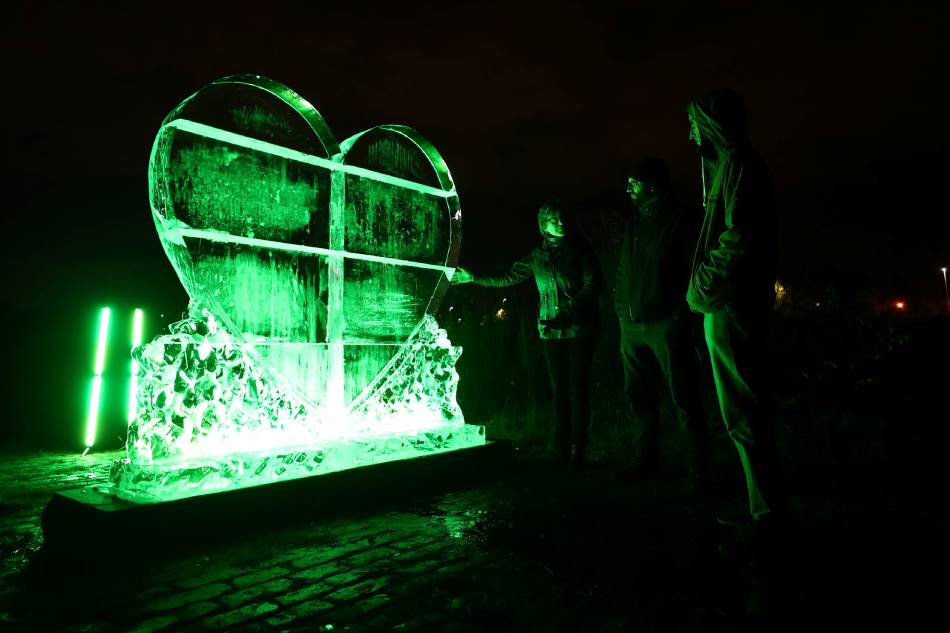 People look at a climate action ice sculpture that was unveiled on the bank of the River Clyde during the UN Climate Change Conference (COP26) in Glasgow, Scotland, Britain, November 7, 2021. Hannah McKay, Reuters/File