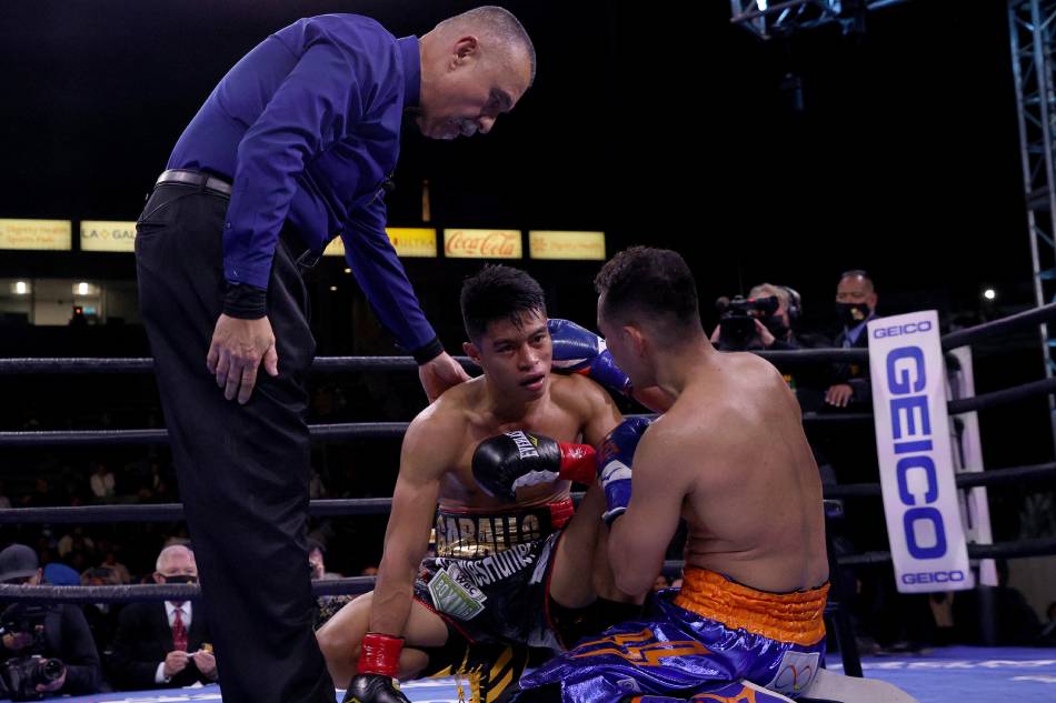 Reymart Gaballo is consoled by Nonito Donaire with referee Ray Corona after a third round knockout loss to Donaire for the WBC World Bantamweight Championship at Dignity Health Sports Park on December 11, 2021 in Carson, California. Harry How, Getty Images/AFP