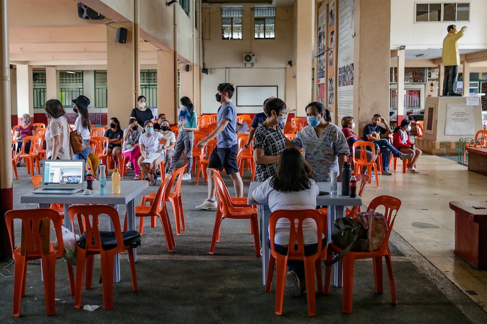 Manila residents register at a vaccination site at the Ramon Magsaysay High School in Manila on December 30, 2021. George Calvelo, ABS-CBN News