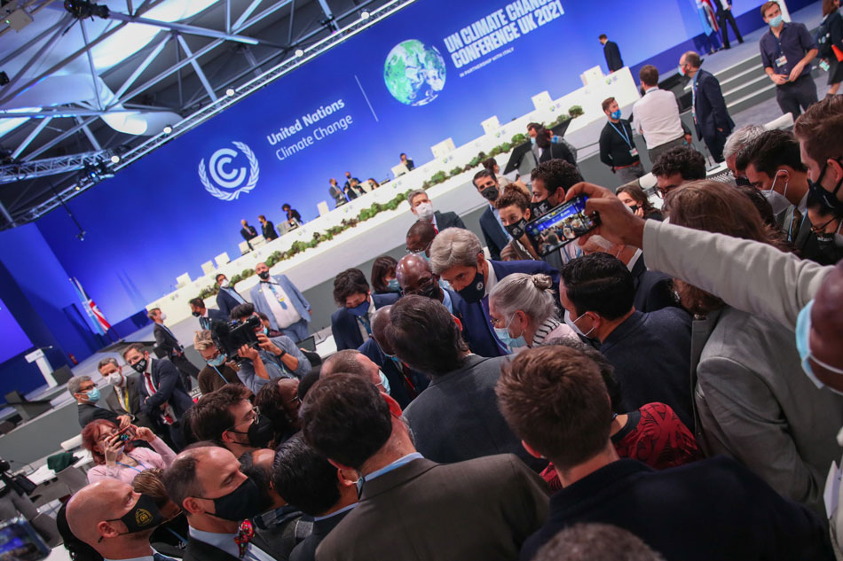 COP26 delegates huddle on the final day of negotiations. Photo source: UNFCCC Flickr account [LINK OUT 