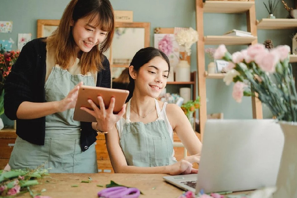 Photo source: Pexels [LINK OUT 'Pexels': https://www.pexels.com/photo/happy-multiracial-women-working-on-gadgets-in-floral-store-5410069/
