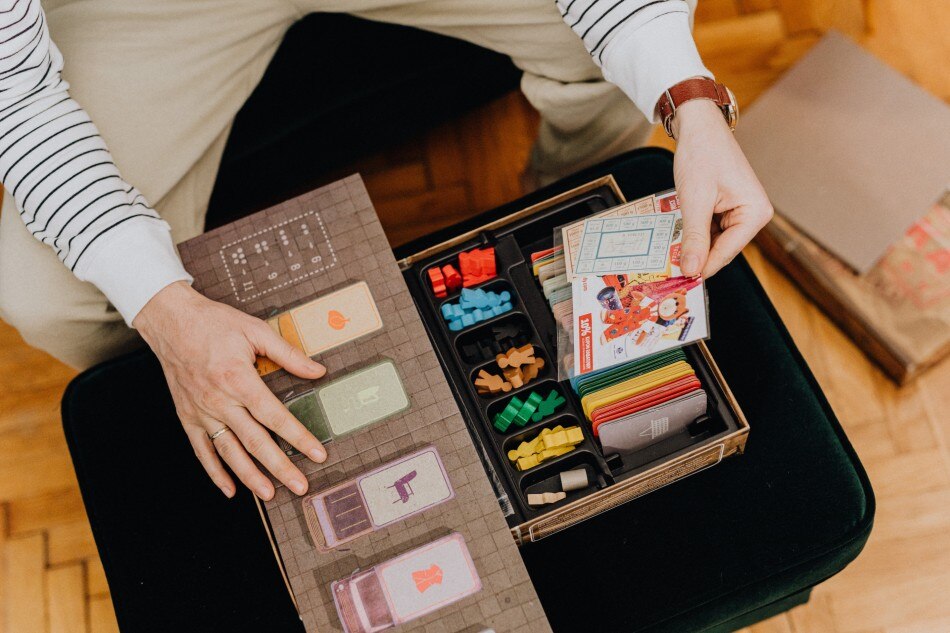 Play cards and board games as a family this rainy season.  Photo Courtesy: Pexels-maps-6333892/[LINKOUT'Pexels':https://wwwpexelscom/photo/high-angle-view-of-a-man-opening-a-vintage-board-game-and-finding-ration-cards-6333892/[LINKOUT'Pexels':https://wwwpexelscom/photo/high-angle-view-of-a-man-opening-a-vintage-board-game-and-finding-ration-cards-6333892/
