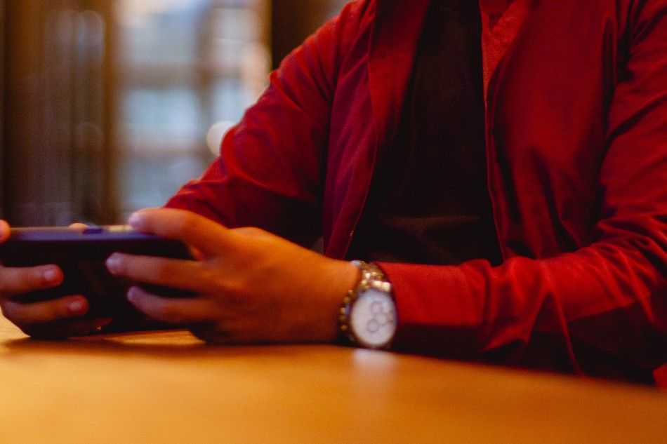 Photo source: Pexels [LINK OUT 'Pexels': https://www.pexels.com/photo/man-in-red-long-sleeve-shirt-holding-a-cellphone-8907361/