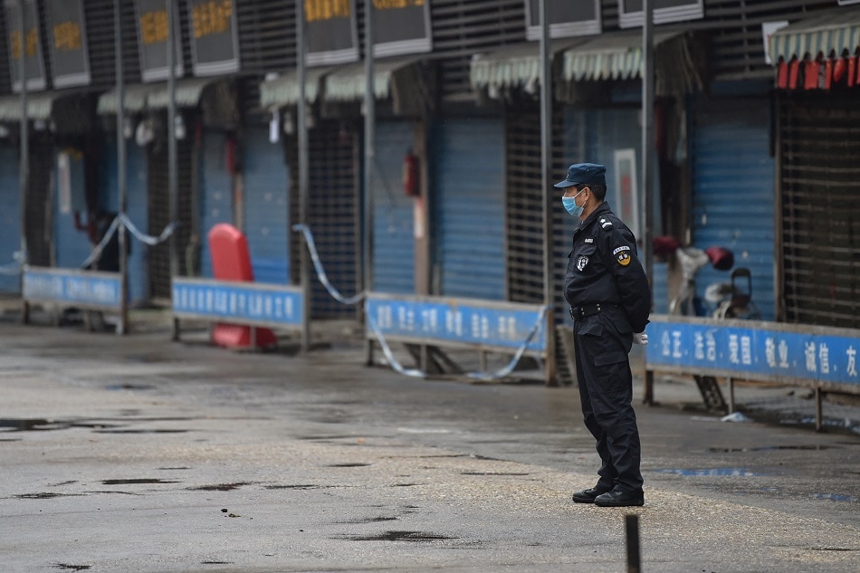 A security guard stands outside the Huanan Seafood Wholesale Market on January 24, 2020 where the coronavirus was detected in Wuhan. Hector Retamal, AFP