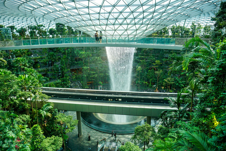 A couple stands on a bridge next to the Rain Vortex in Changi Jewel in Singapore on November 18, 2021. Roslan Rahman, AFP/File