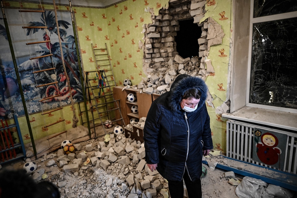 A woman stands inside among debris after the reported shelling of a kindergarten in the settlement of Stanytsia Luhanska, Ukraine, on Thursday. U.S. Defense Secretary Lloyd Austin warned of a provocation by Moscow to justify military intervention in Ukraine after 
