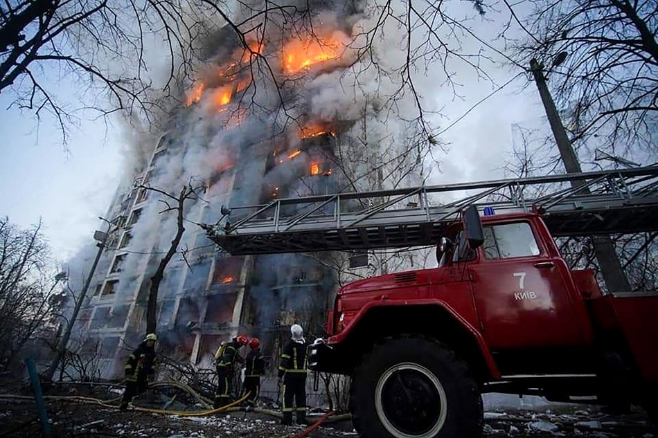 In this handout picture taken and released by the State Emergency Service of Ukraine on March 15, 2022, firemen work to extinguish a fire in a housing block hit by shelling in the Sviatoshynsky district in western Kyiv. Handout, State Emergency Service of Ukraine via AFP/File photo