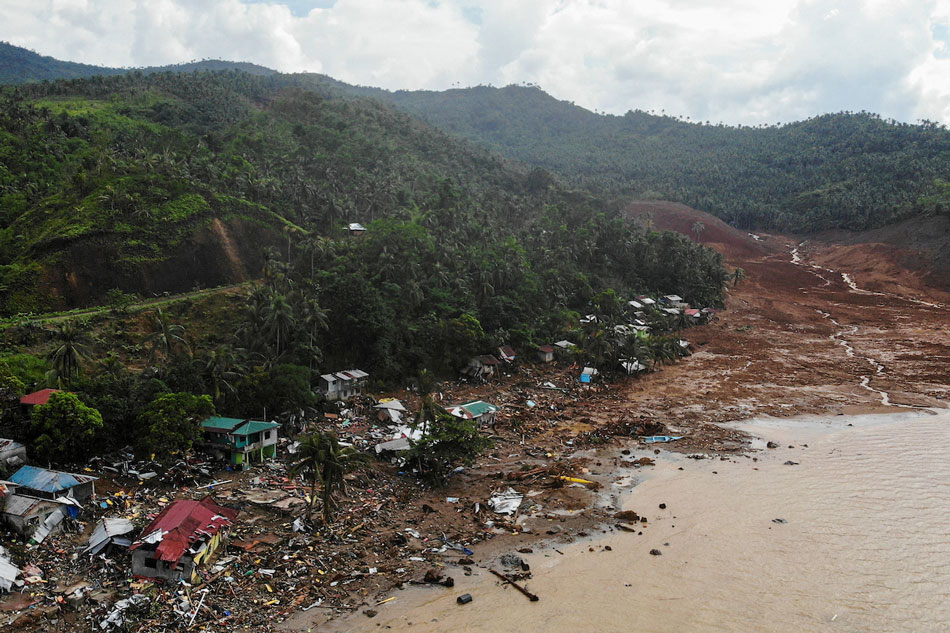 An aerial view shows destroyed houses on a collapsed mountain side along the coastline in the village of Pilar, Abuyog town, Leyte province on April 14, 2022 day after a landslide struck the village due to heavy rains at the height of Tropical Storm Agaton (international name Megi). Bobbie Alota, AFP