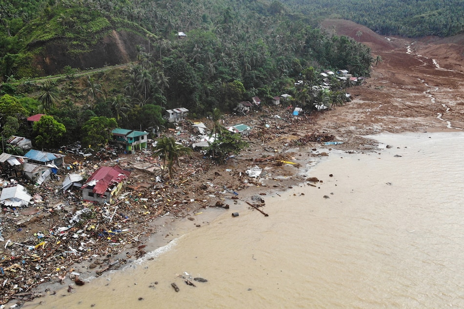 An aerial view shows destroyed houses on a collapsed mountain side along the coastline in the village of Pilar, Abuyog town, Leyte province on April 14, 2022 day after a landslide struck the village due to heavy rains at the height of Agaton. Bobbie Alota, AFP