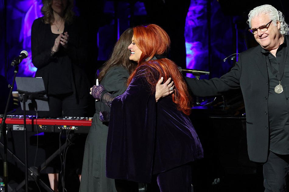 (L-R) Ashley Judd accepts induction on behalf of Naomi Judd with inductee Wynonna Judd and Ricky Skaggs onstage for the class of 2021 medallion ceremony at Country Music Hall of Fame and Museum in Nashville, Tennessee. Terry Wyatt, Getty Images for Country Music Hall of Fame and Museum/AFP