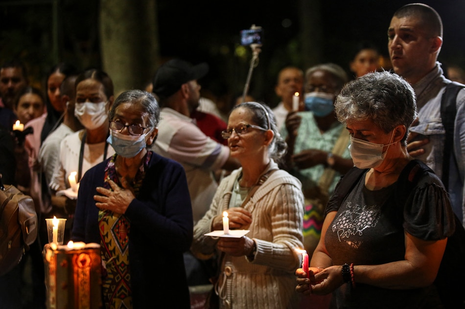 People attend a candlelight vigil near the prison in Tulua, Valle del Cauca Department, Colombia, on June 28, 2022, after several prisoners died when rioting inmates set a fire early in the morning to try to prevent police entering their enclosure. At least 52 inmates were killed and 26 more injured early Tuesday after a fire broke out during a prison riot in southwestern Colombia, the national prisons agency said. AFP Stringer 